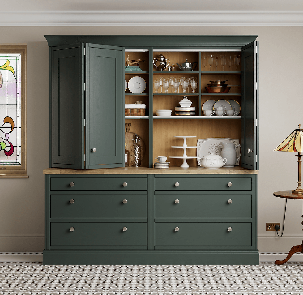 Green cabinet with open doors displays dishes, glasses, and teapots. Stained glass window and patterned floor create a vintage kitchen vibe.