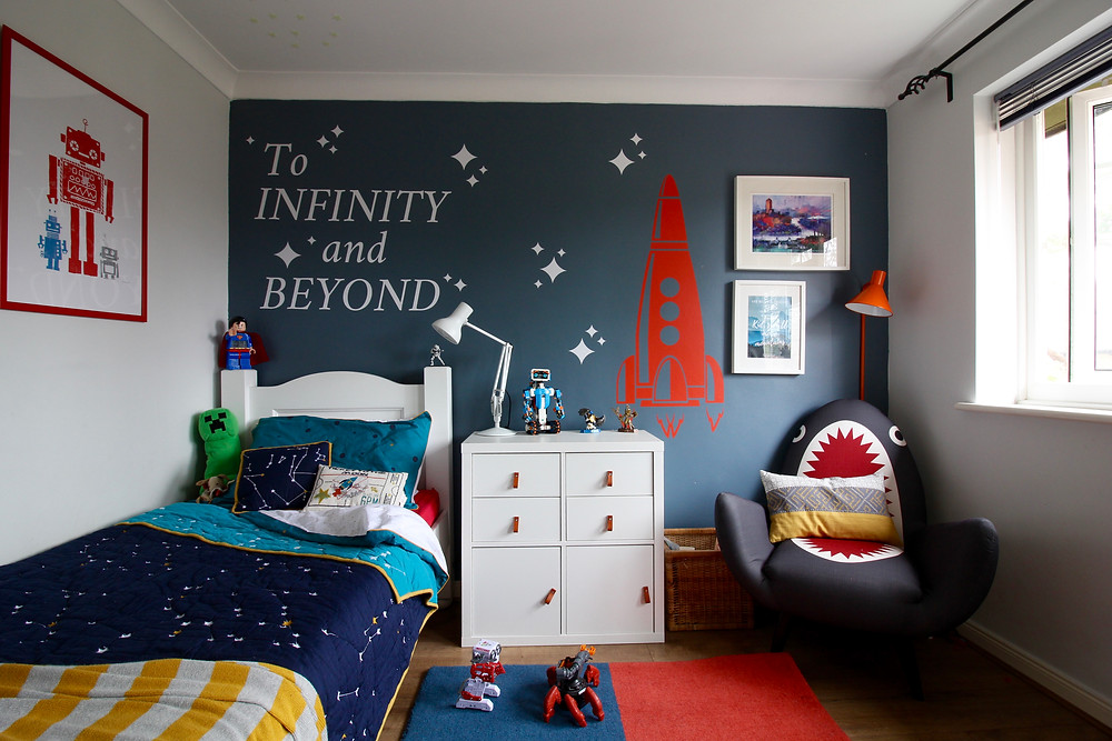 Room Reveal: Spare room turned home office | seasonsincolour.com | a room with blue wall Dulux steel symphony 1 and shark chair by made.com, wall stickers with rocket and ikea kallax storage, a white bed with duvet covered in stars