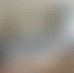 Cozy kitchen with light blue cabinets, silver range hood, and wooden floor. Sunlit table set with cups, neutral décor, and plants.