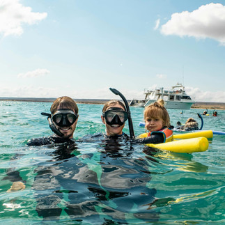 family with small child snorkelling