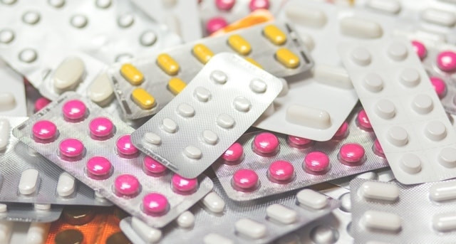pile of multi-colored prescription drugs in blister packs