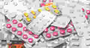 pile of multi-colored prescription drugs in blister packs
