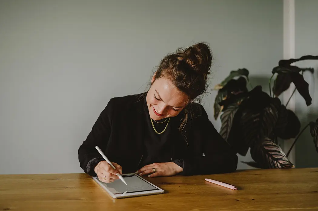Authentische Arbeitsszene mit Tablet und Stift – kreative Selbstständigkeit und Designprozess sichtbar gemacht.