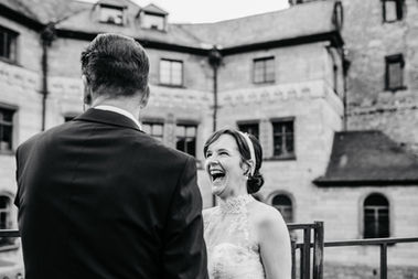 Strahlendes Glück: Die Braut lacht ihren Bräutigam mit einem strahlenden Lächeln an. Die Freude und das Glück des Moments spiegeln sich in ihrem Lachen wider, während sie gemeinsam in die Zukunft blicken. Ein herzerwärmender Augenblick voller Liebe und Lebensfreude, der die besondere Bindung zwischen Braut und Bräutigam unterstreicht.