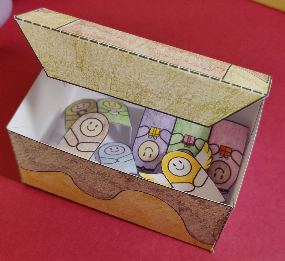 Colourful paper box with an open lid revealing cheerful Nativity characters inside. .