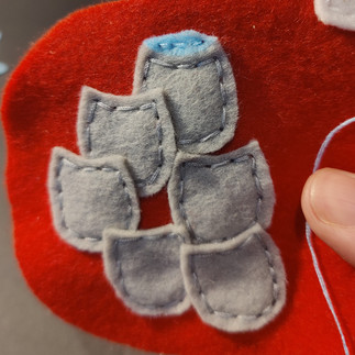Grey and blue felt shapes on red felt background.