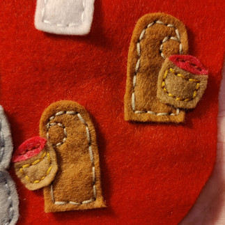 Brown and wine coloured felt shapes on red felt background.