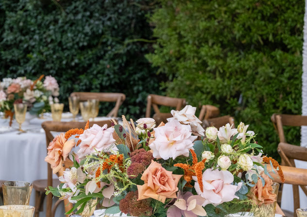 Round table for rent with white linen for rent paired with cross back chairs for rent in Los Angeles with clear gold rim glass charger plates for rent and yellow glass water goblets and fresh floral centerpieces for wedding