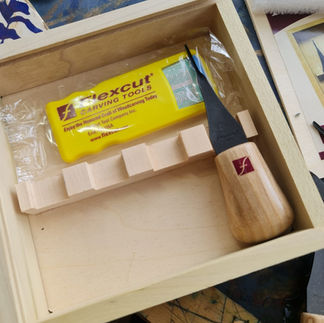 A Linocut block being carved by relief printmaker Moatzart with linocut carving tools