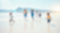 Family running on white sand beach with beautiful mountain in the background. Two children-a boy and a girl are running in front of the adults.
