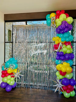 Silver Tinsel Wall with Happy Birthday Neon Sign and Balloon Arch