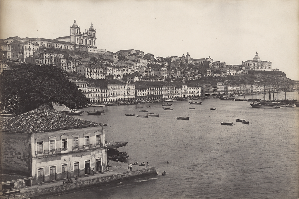 Vista histórica da Baía de Todos os Santos em Salvador, destacando a icônica arquitetura colonial da cidade e embarcações tradicionais no porto.