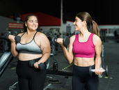 two young women at the gym lifting weights