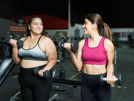 two young women at the gym lifting weights