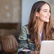 a young smiling woman looking through a window
