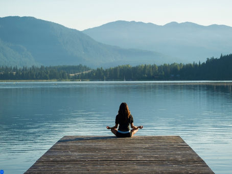 a woman doing yoga by the lake