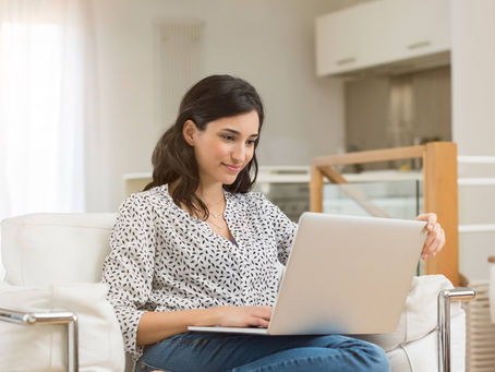 a woman looking at her computer and smiling