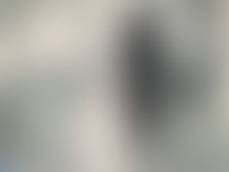 A nurse in a hospital pushing a hospital bed down a hallway