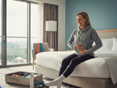 a woman with exercise outfit sitting on a hotel bed