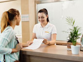 a hotel receptionist checking in a female customer