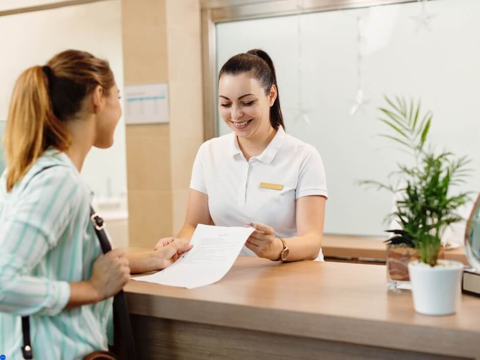 a hotel receptionist checking in a female customer