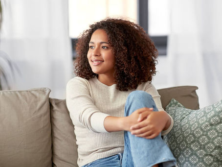 a young smiling woman sitting on a couch