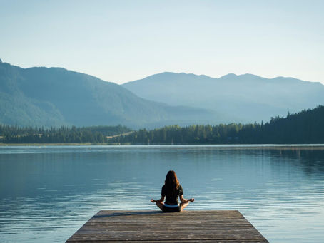 a woman doing yoga by a lake