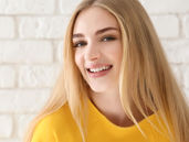 a young smiling blonde woman with a yellow top