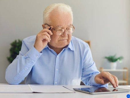 a senior man with blue shirt reviewing medical documents