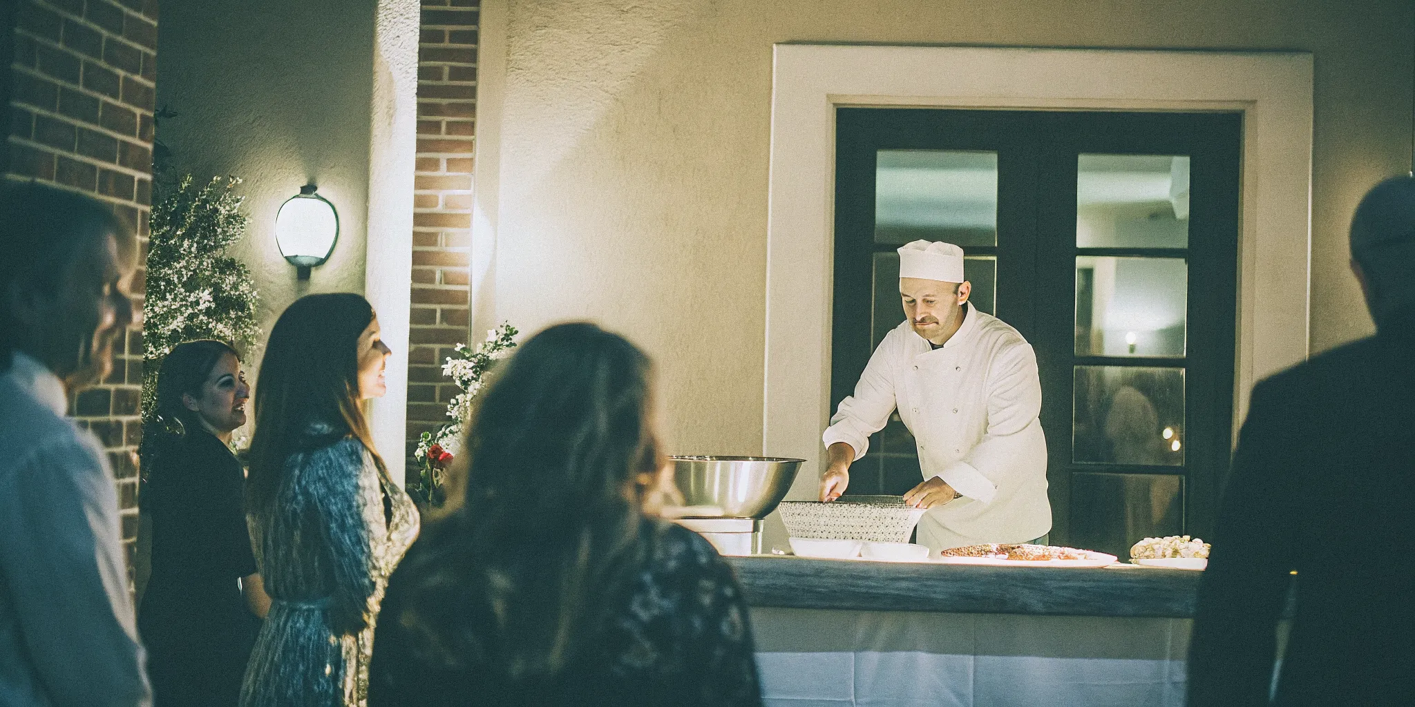 Chef preparing made-to-order pasta at a live cooking station for a San Diego wedding reception