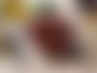 A bowl of appetizing, deep red, salad dressing with a whisk balanced beside it