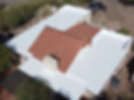 Aerial view of building with white flat roof and red tile roof.