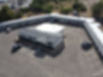 Aerial view of building complex with new construction roofing