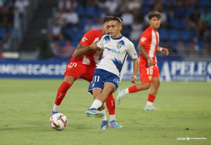 Luismi Cruz jugador del Tenerife sujetado por Centelles tras dar un pase.