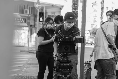 Professional videographer operating a film camera.