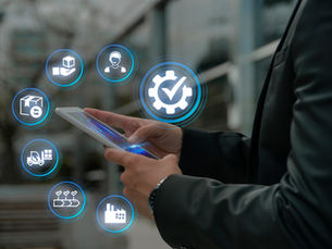Person in a suit using a tablet with futuristic icons floating around, suggesting logistics and technology concepts. Urban background.