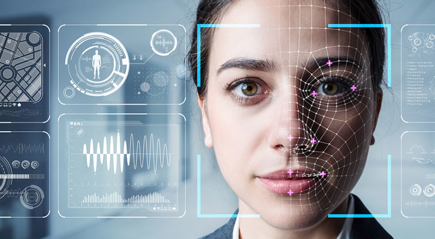 A woman with facial recognition graphics overlaid, surrounded by digital interface screens displaying various data, in a tech setting.
