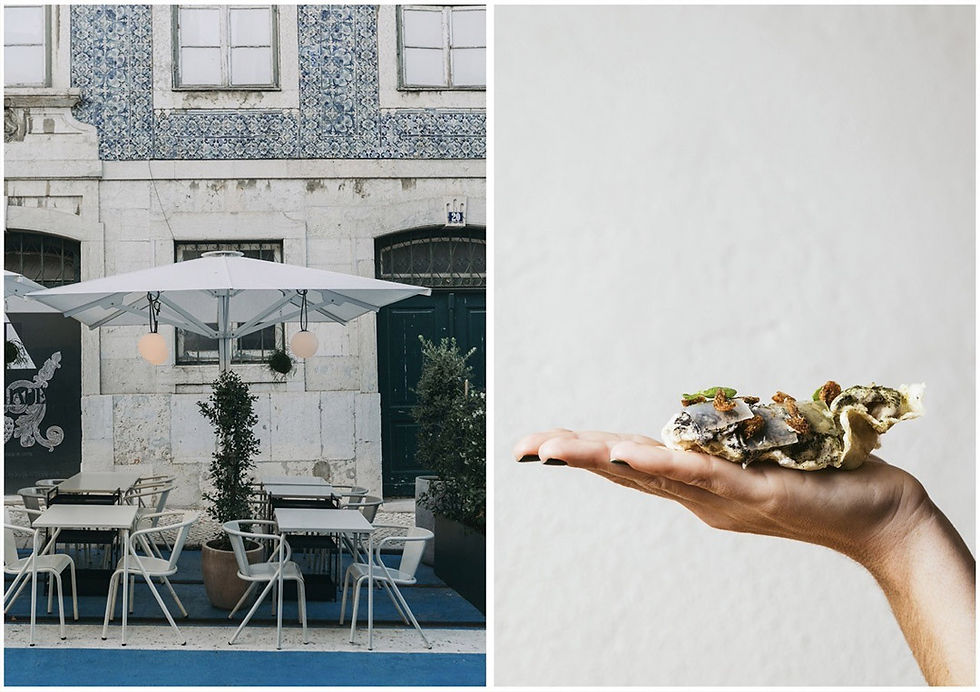 Café ao ar livre com mesas e guarda-sol branco; à direita, mão segura comida gourmet em prato claro. Fachada com azulejos azuis ao fundo.