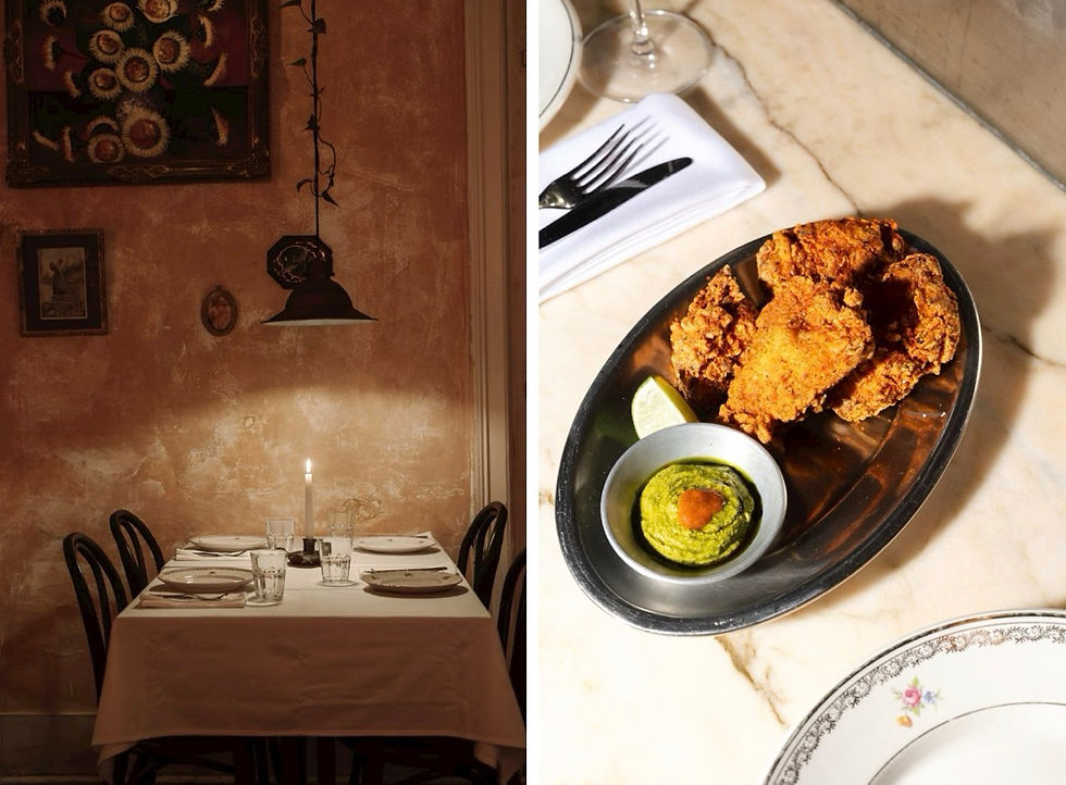 Mesa para dois com vela acesa em sala rústica à esquerda; à direita, frango frito com molho verde e limão em prato metálico.