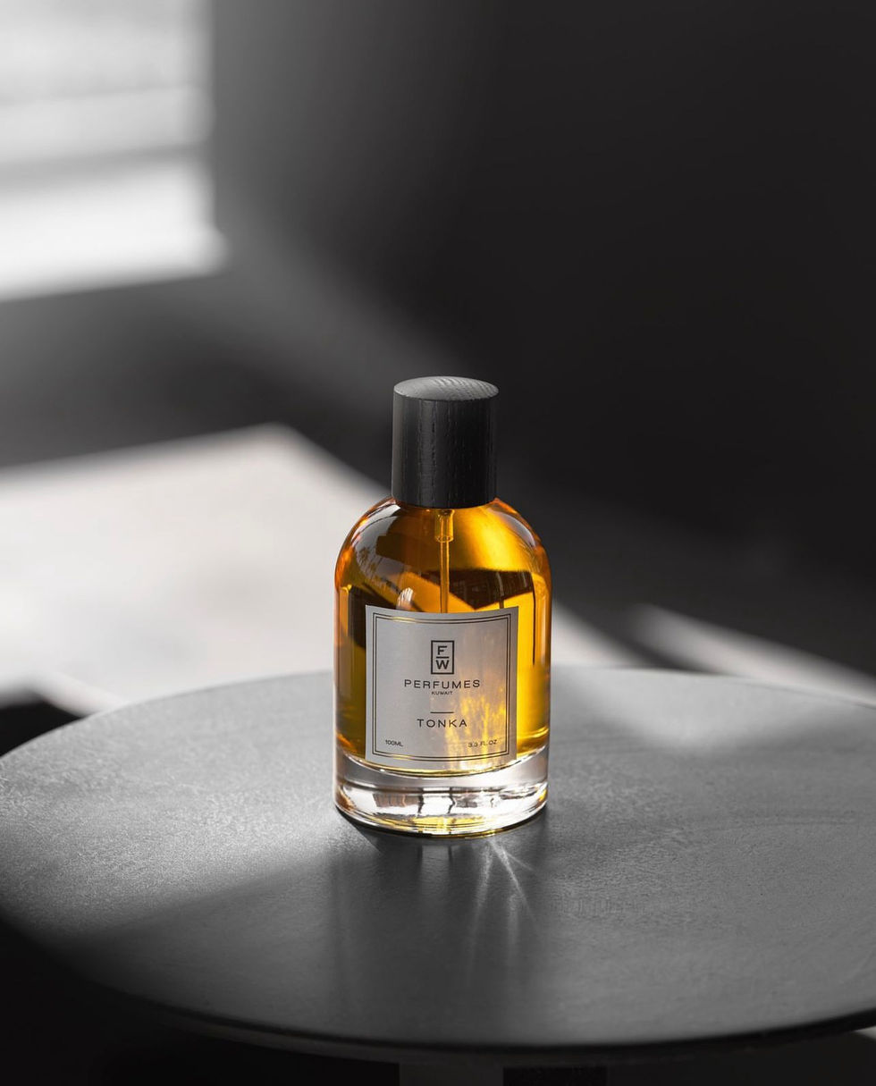 "Luxury fragrance bottle on a table with soft lighting and dark background."