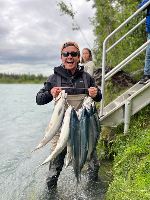 excited fisherman posing with daily catch of salmon