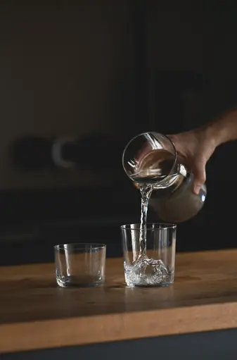 Wasser wird in Glas eingeschenkt ruhige Detailaufnahme