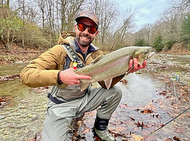 An angler catching a steelhead on a fly rod, showcasing the thrill of guided fly fishing trips with Shenandoah Valley Adventu