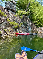 Fly fishing in a scenic river setting with a snack break, showing the relaxed and rewarding experience of guided trips with S