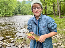 A smiling child proudly holding a large trout he caught during a guided trip with Shenandoah Valley Adventure Co.