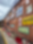 A red brick wall with a set of vintage metallic banners and signs
