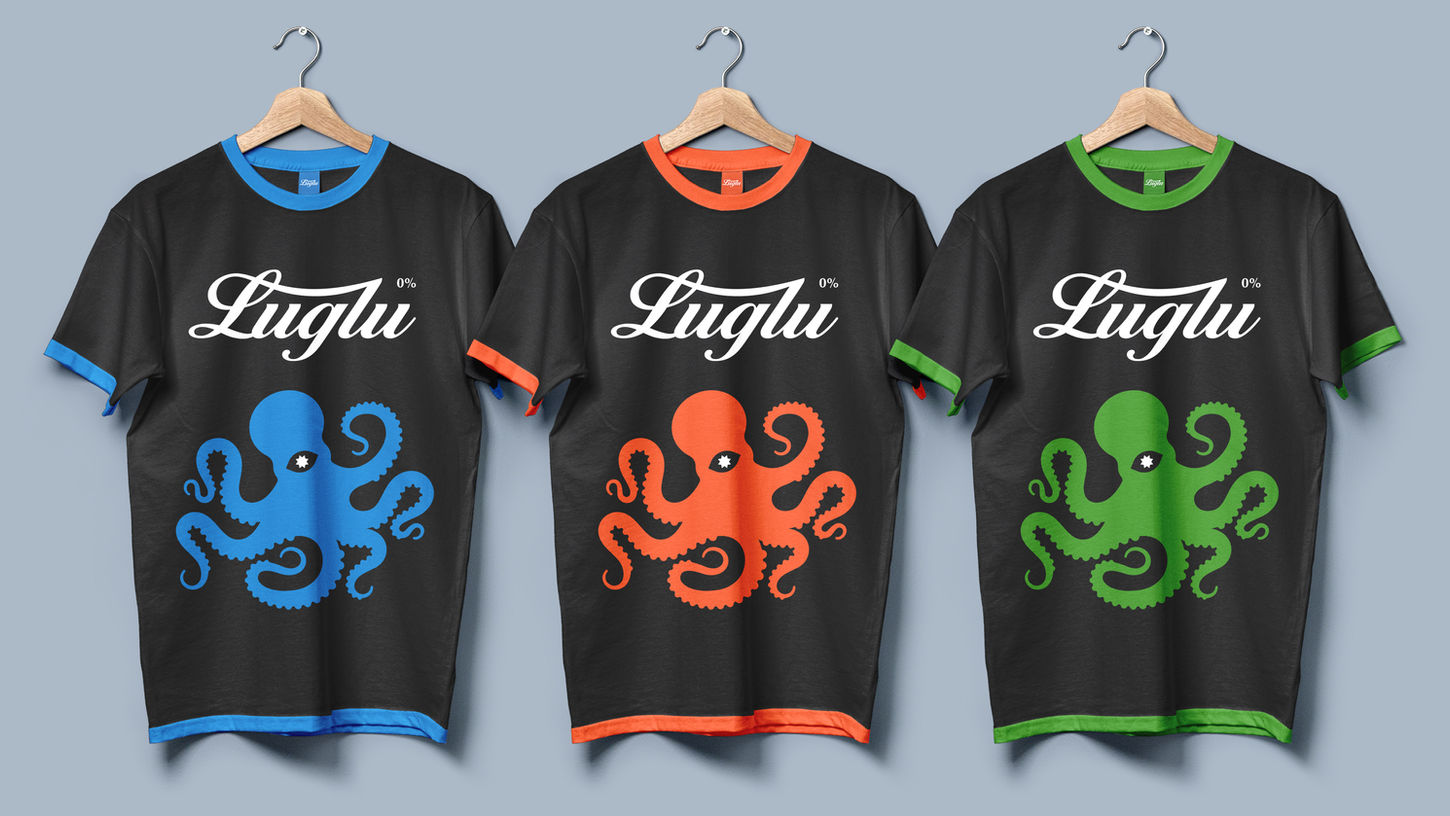 Three black crew-neck t-shirts on hangers with colored collar trim in blue, orange, and green, featuring the white Luglu logo and matching octopus graphics on the chest.