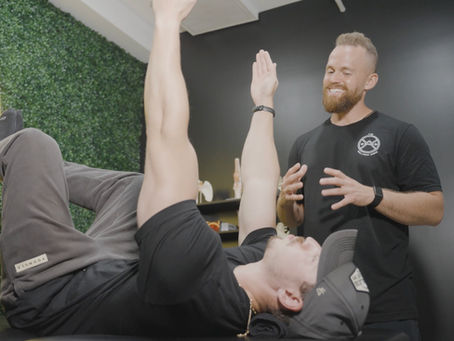 physical therapist conducting one-on-one assessment with an active adult patient in a modern PT clinic