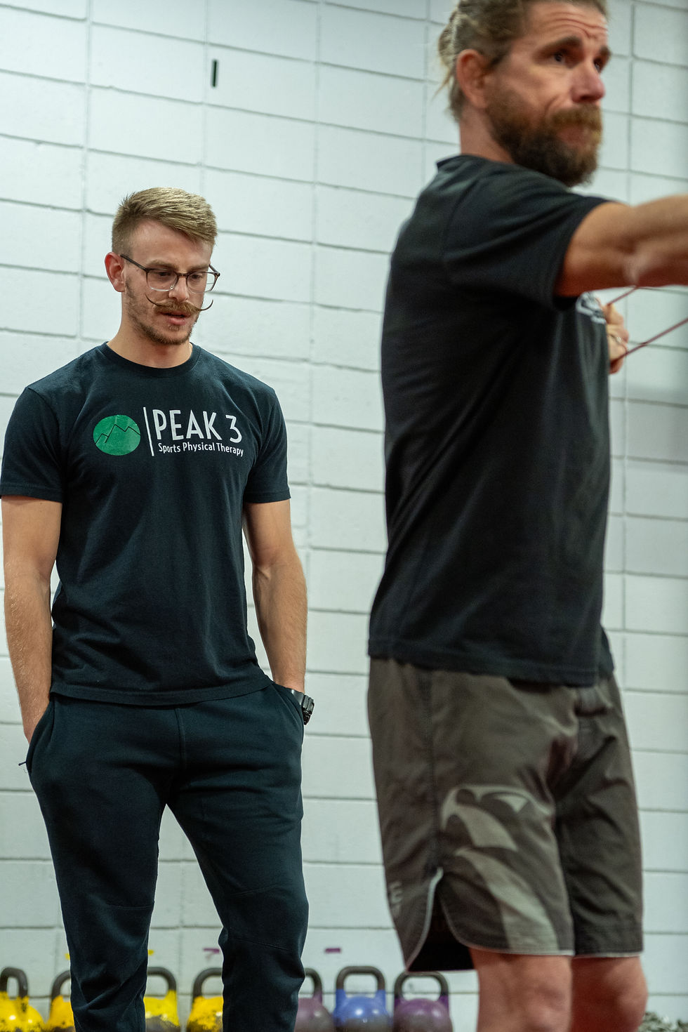 Doctor of Physical Therapy guiding an athlete through resistance training exercises in a performance-focused rehabilitation setting