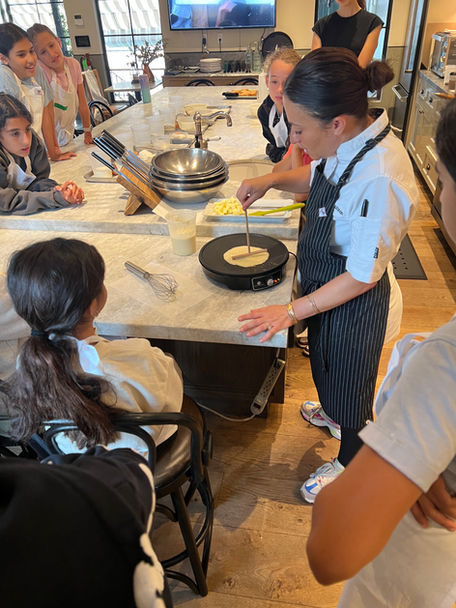 Culinary instructor is leading a class for kids at Violet Cooking School.
